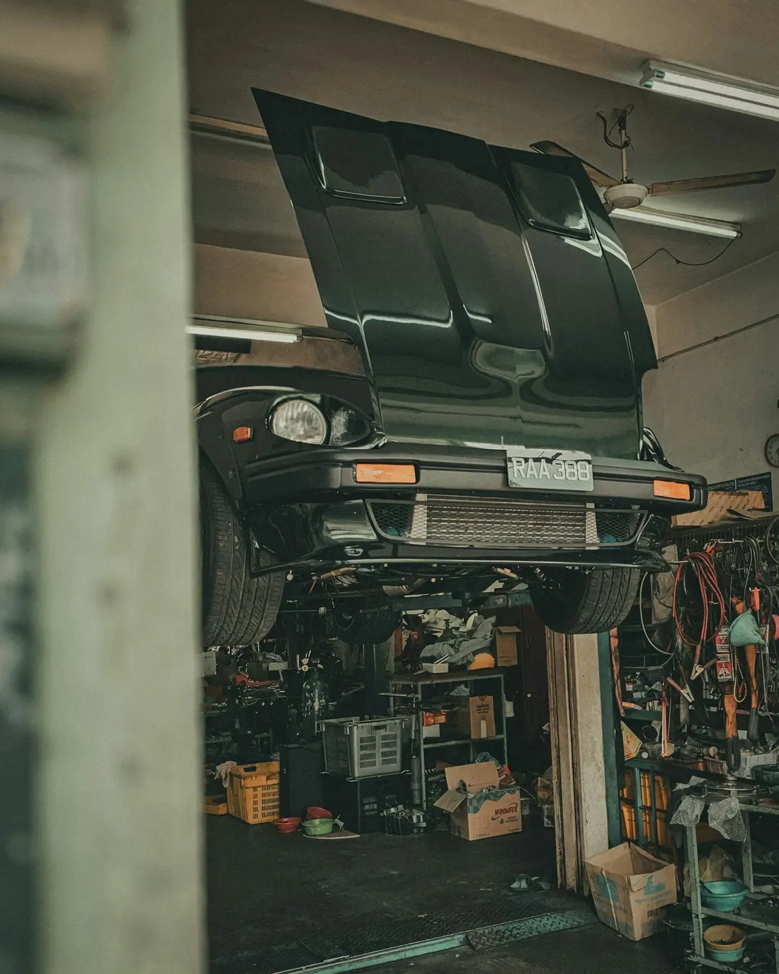 A car on a lift inside a workshop